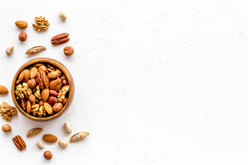 Mixed nuts in bowl - healthy snack - on white background top-down frame copy space