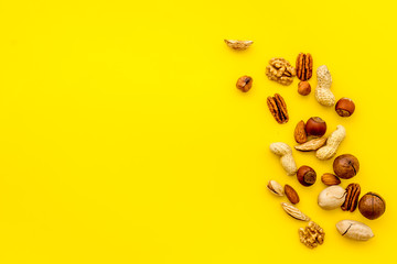 Nuts background - healthy snacks concept - on yellow table top-down frame copy space