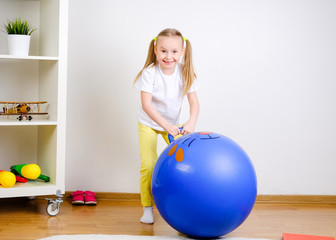 The child plays with the ball. Girl jumping on a big ball