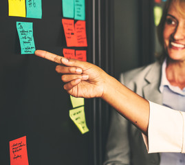 Businesspeople planning tasks with sticky notes