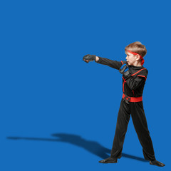 Naklejka premium Young boy in kimono practicing taekwondo and making hit