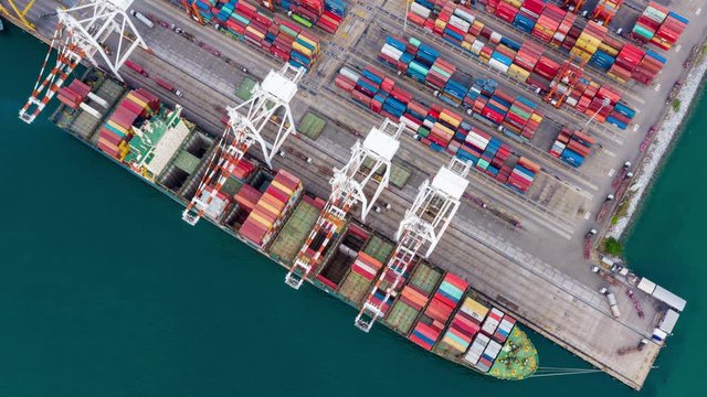 time lapse aerial top view shipping terminal loading unloading with crane and trailer transportation and shipping containers import and export international open sea 4k 