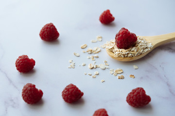 Healthy breakfast, close-up of spoon with oatmeal and raspberry 