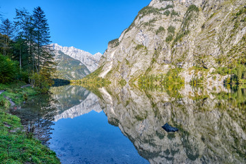 Fototapeta na wymiar The lovely Obersee in the Bavarian Alps with a reflection of the mountains in the water