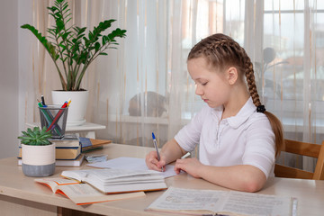 Schoolgirl studying at home. Distance education, home education. Self isolation concept