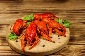 Boiled crayfish on cutting board on wooden table