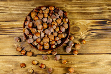 Hazelnuts in ceramic plate on a wooden table. Top view