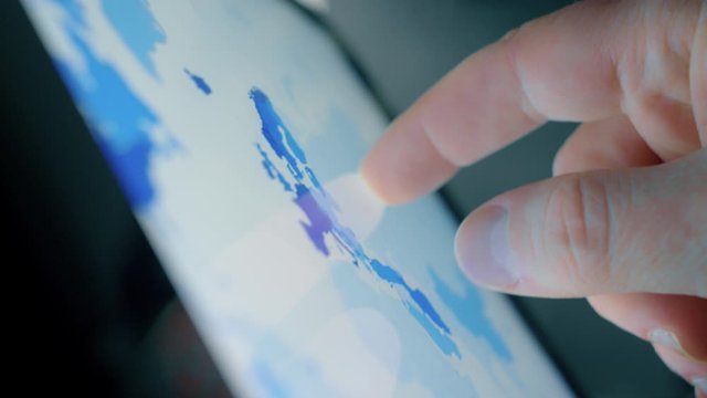 Man pinching and zooming a map using a tablet iPad pro retina display closeup shot of the fingers