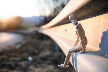 Wooden mannequin with face mask by road, corona virus and lockdown concept.