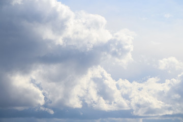 Grey cumulus clouds flies in the sky after rain. A piece of blue sky is visible next to large clouds. Theme of weather forecast.