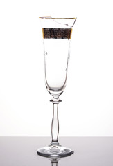 A broken glass of champagne on a white background.