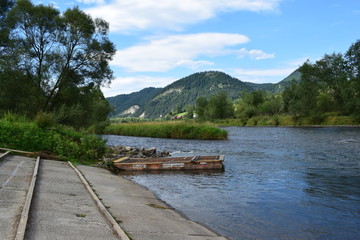 Fototapeta premium river flowing in the mountains and rafter boat
