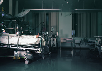 Patient surrounded by advanced life saving equipment in the intensive care unit at night