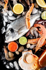 Fish and seafood. Sea bream with scallops, caviar, shrimps and lemons and limes, shot from above