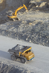Mining dump truck and excavator in a quarry in a mining enterprise. © esalienko