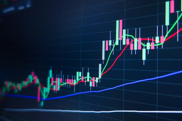 Naklejka premium Stock market trading graph and candlestick chart on screen monitor background. Financial investment and economic concept.