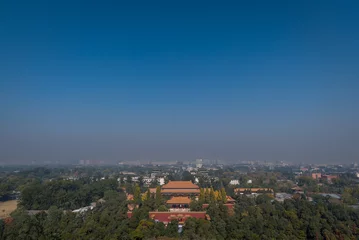Foto op Canvas Scenic view overlooking the city of Beijing from Jingshan Park Palace gardens with temples, houses, rooftops and hazey blue sky in the background. © Matthew