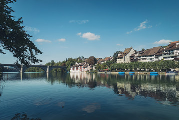 Obraz premium Reflections of medieval town houses and buildings along the river Rhine in the Swiss village of Eglisau in Switzerland