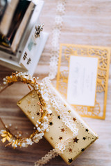 Wedding composition decorated with  gold and pearl jewelry and invitation letter on the wooden table with lace. Jewelry closeup details from morning of the bride.