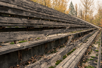 Detail of broken wooden seat benches on grandstand of abandoned sports arena in Pripyat, Chernobyl...