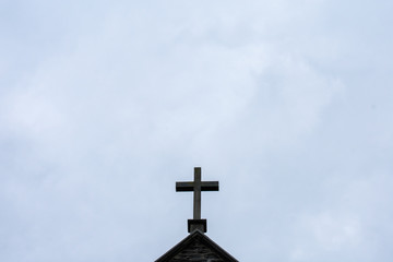 A Cross on a Roof on a Cloudy Sky