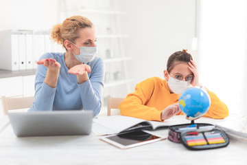 Fototapeta premium Child home studying education, homeschooling, with private tutor / mother with protective mask in the time of viruses, flu and seasonal pandemic, healthy approach in social contact.