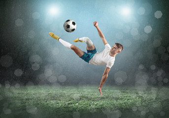 Fototapeta na wymiar Soccer player on a football field in dynamic action at summer da