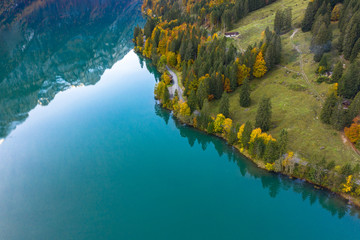 Luftaufnahme von einer Strasse an einem Herbstlichen See, in den Alpen. - 339071943