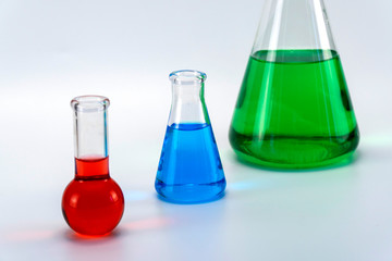 Laboratory glassware with liquid on white background. glass chemical flask with reagent. glass technical vessel