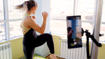 Fitness training online. Woman conducts training on the Internet through a smartphone.