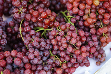 A bunch of purple grapes, a large number of grapes, are on the market.