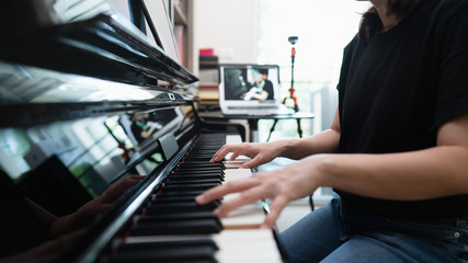 Scene of piano lessons online class or E-learning while Coronavirus spread out or covid 19 crisis situation, vlog or teacher make online piano lesson to teach students pupils, Training from home. - obrazy, fototapety, plakaty