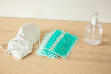 Medical face mask with alcohol sanitizer gel hand wash on wood table for covid-19 Coronavirus prevention concept