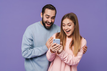 Excited surprised loving couple using mobile phone.