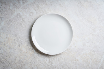 Clean white plate on the rustic background. Selective focus. Shot from above.
