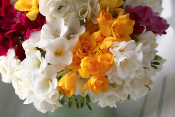 Beautiful bouquet with fresh freesia flowers on light background, closeup