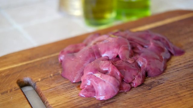 red raw chicken liver on wooden board