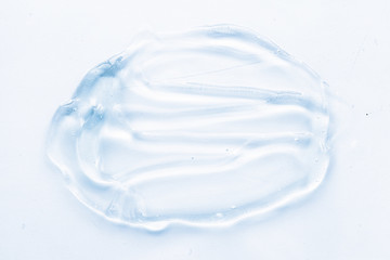 Naklejka na ściany i meble Transparent liquid gel cream smudge on white background