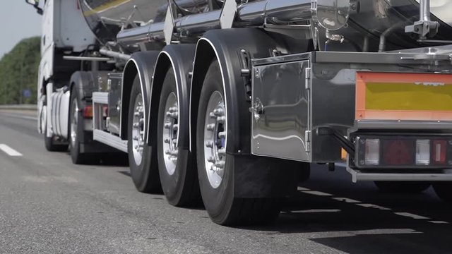 Low angle shot of the back of a driving gasoline tanker truck. Cargo transportation concept