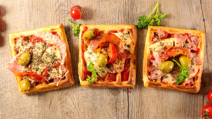 waffle pizza with tomato sauce, cheese, olive and ham