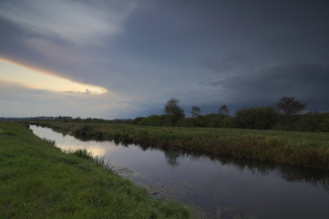 Meadows and river in the evening, at sunset time