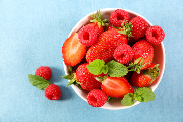 bowl of berry fruit salad on blue background