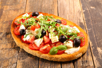 bruschettas, bread toast with tomato, mozzarella, olive and mozzarella