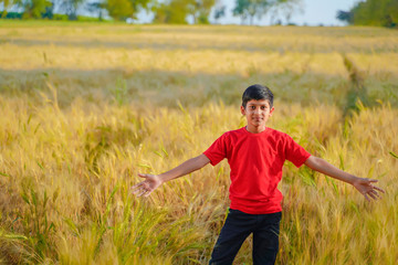 Naklejka na ściany i meble young indian child playing at wheat field, Rural india