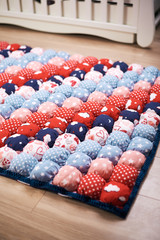 Multicolored soft mat for babies to the children 's room. multi-colored cubes. Lies on the floor by the children 's bed