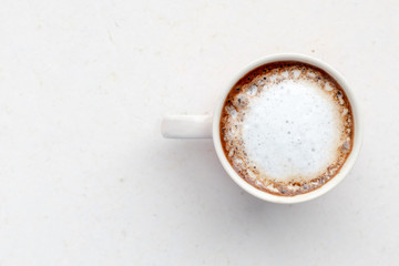 Mug of coffee with milk on a light background.