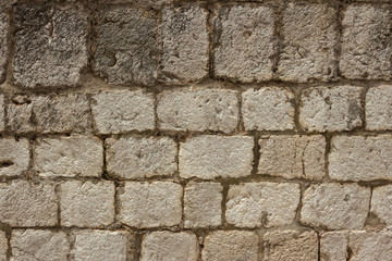 Wall texture of castle fortress in Dubrovnik old town, Croatia having green grass