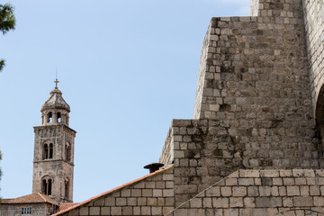 Fototapeta na wymiar Ancient church top view, and stairs of Dubrovnik old town, hand made walls build with old bricks and stones, clock tower, bell tower, Croatia
