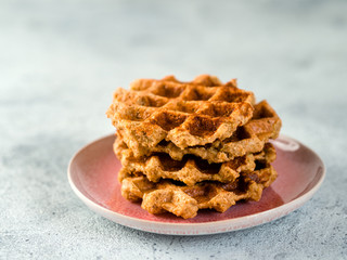 Easy healthy gluten free oat waffles with copy space. Stack of appetizing homemade waffles with oat flour on plate over light gray cement background