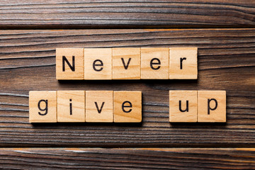never give up word written on wood block. never give up text on wooden table for your desing, concept